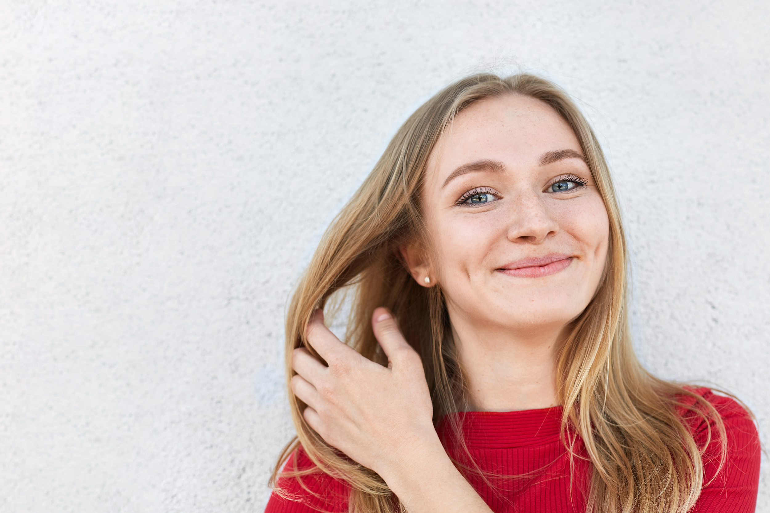 Smiling woman with dimples flicking her hair, dimple surgery